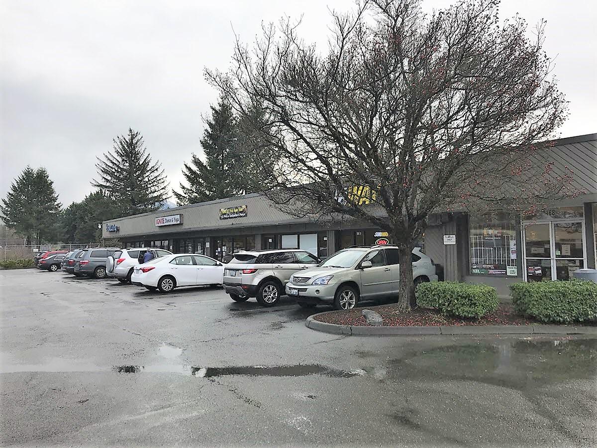The fully leased retail strip center in North Bend, with storefronts and parking along the main arterial